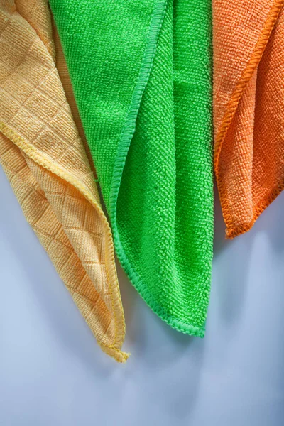 Colorful new household dishwashing rags on white background.
