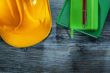 Kask ahşap tahta üzerinde bina defter kalem kümesi.