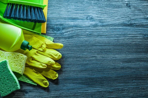 Assortment of household cleaning objects on vintage wooden board.