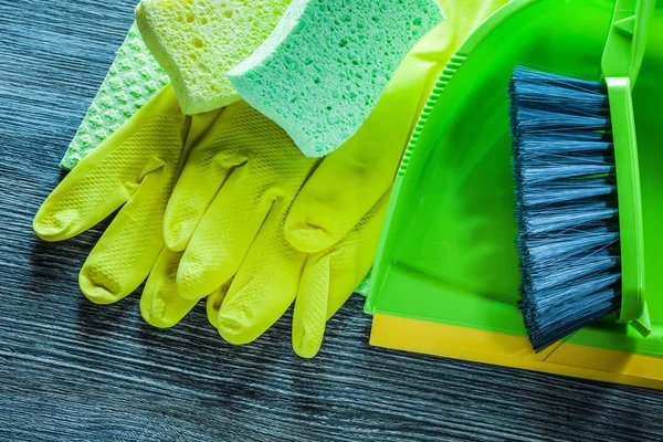 Set of household cleaning tools on vintage wooden board.