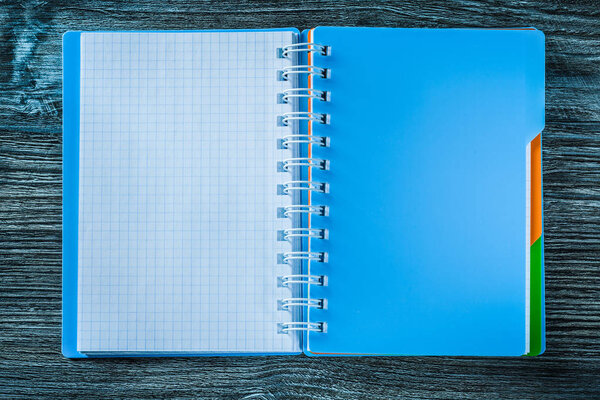 Opened notepad on wooden board.