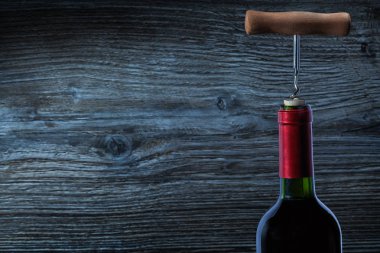 bir şişe kırmızı şarap ve corckscrew üzerinde üstten görünüm
