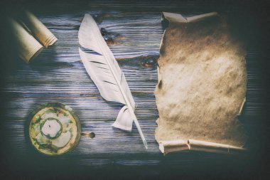 Mavi ahşap arka plan üzerinde tüy şamdan top Vintage kağıt.