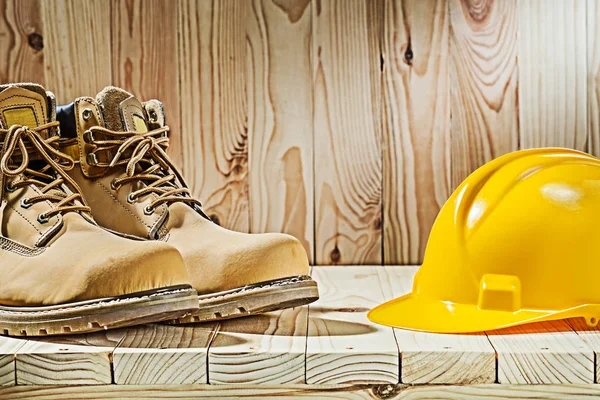 Botas de vista de cerca y casco sobre fondo de madera — Foto de Stock