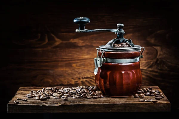 Moulin à café en céramique vintage avec haricots sur panneau de bois — Photo