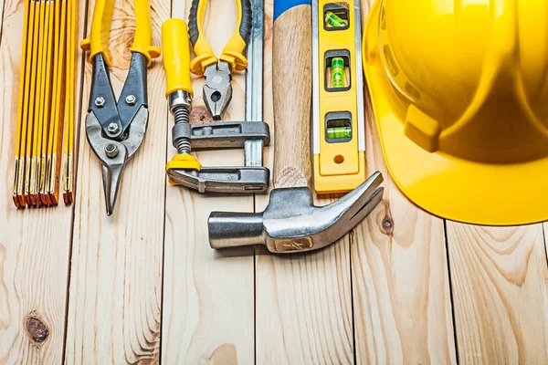 Casco amarillo y herramientas de construcción en tableros de madera —  Fotos de Stock