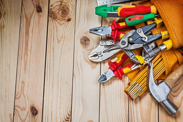 Construction tools in leather toolbelt on wooden boards — Stock Photo, Image