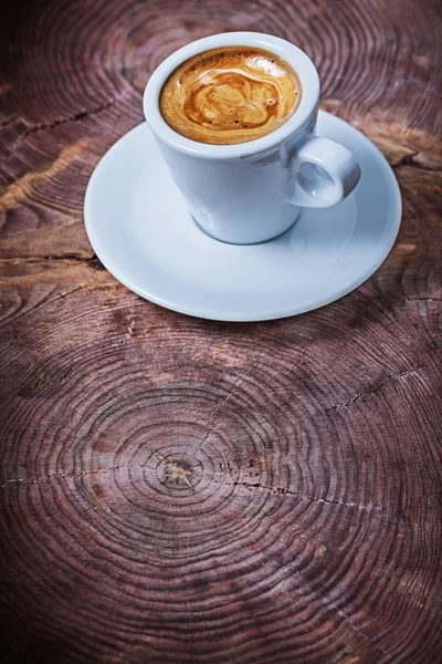 Vertical view capuchino in white coffee cup on vintage wood cros — Stock Photo, Image