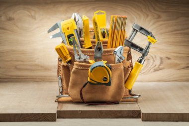 leather tool belt with construction tools on wood backgeound clipart