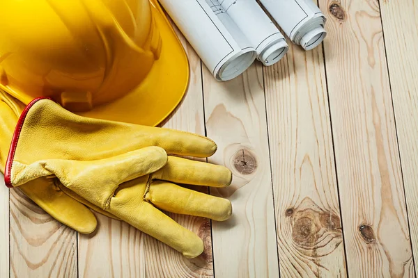 Guantes casco y planos de construcción en madera —  Fotos de Stock