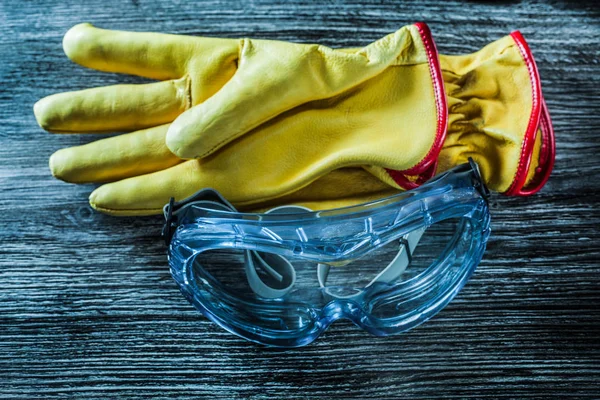 Rękawice ochronne skórzane okulary na drewnianej płycie — Zdjęcie stockowe