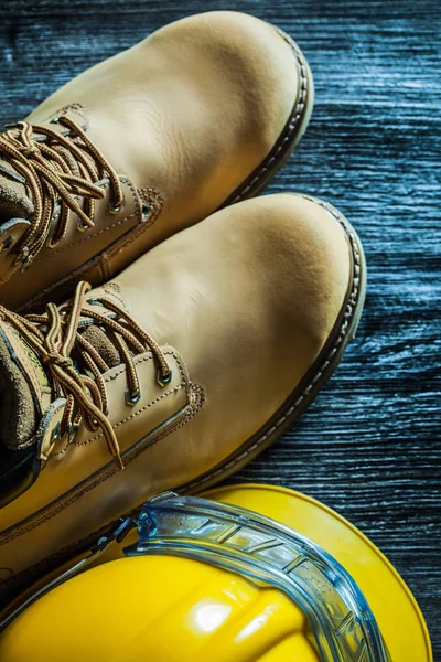 Botas de segurança óculos de boné na placa de madeira vintage — Fotografia de Stock