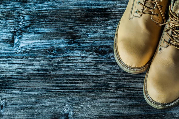 Botas de seguridad sobre tabla de madera vintage —  Fotos de Stock