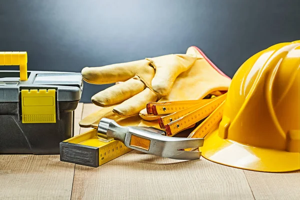 Boîte à outils noire gants marteau niveau casque de compteur en bois — Photo