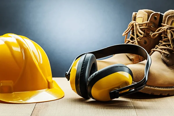 Auriculares de construcción amarilla casco y botas de trabajo —  Fotos de Stock