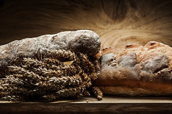 Două bucăți de pâine și o grămadă de urechi pe lemn de epocă — Fotografie, imagine de stoc