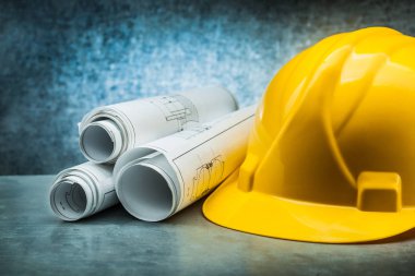 konstrution kask metalik arka plan üzerinde planları haddelenmiş
