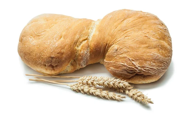 Laib süßes Brot und Weizenähren isoliert auf weiß — Stockfoto
