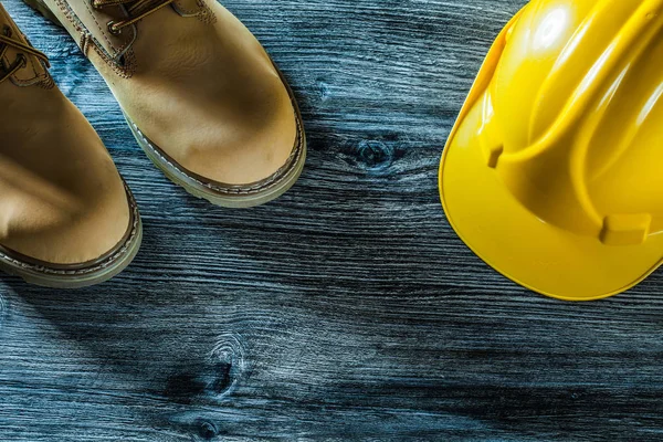 Botas de seguridad sombrero duro en tablero de madera vintage —  Fotos de Stock