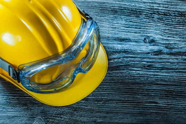 Safety glasses building helmet on vintage wooden board