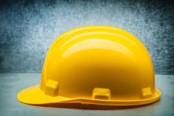 Capacete de construção amarelo no fundo metálico fechar para cima lado — Fotografia de Stock