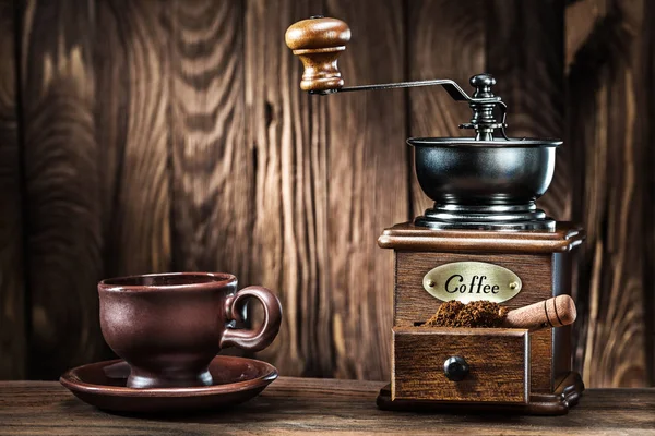 Taza de café de arcilla marrón y molino de madera vintage en madera vieja backgr — Foto de Stock