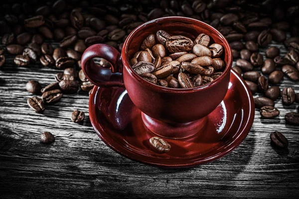 Platillo de taza de granos de café en tablero de madera —  Fotos de Stock