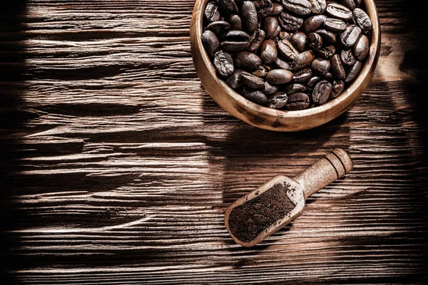 Ground coffee beans bowl scoop on vintage wooden board — Stock Photo, Image