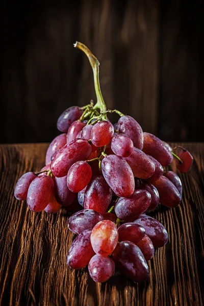 Куча розового винограда на старинной деревянной доске — стоковое фото