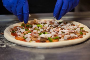 Pişirme pizza, aşçı koyar pizza malzemeleri