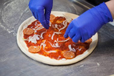 Bir restoranda pizza pişirme pişirmek koyar pizza malzemeleri