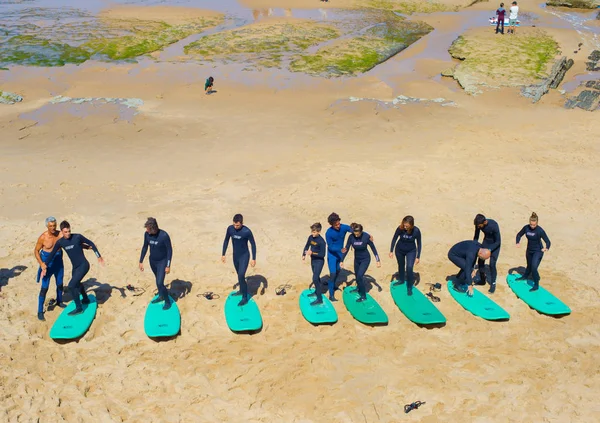 Grupa Ludzi Biorąc Lekcja Surfingu Instruktorem Piaszczystej Plaży Ericeira Portugalia — Zdjęcie stockowe