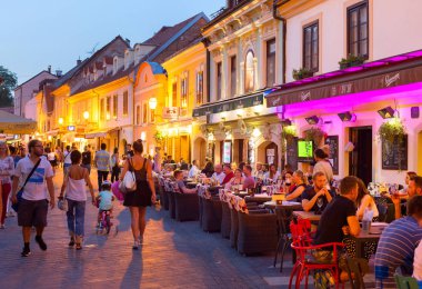 ZAGREB, CROATIA - AUGUST 25, 2017: Locals and tourists having dinner at restaurants at Ivana Racica street. clipart