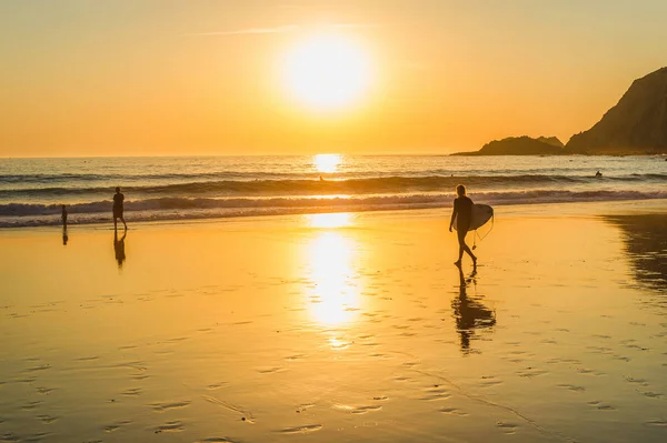在沙滩上走到海边的冲浪者剪影 在海景上的金色日落 萨格雷斯 阿尔加维 葡萄牙 — 图库照片
