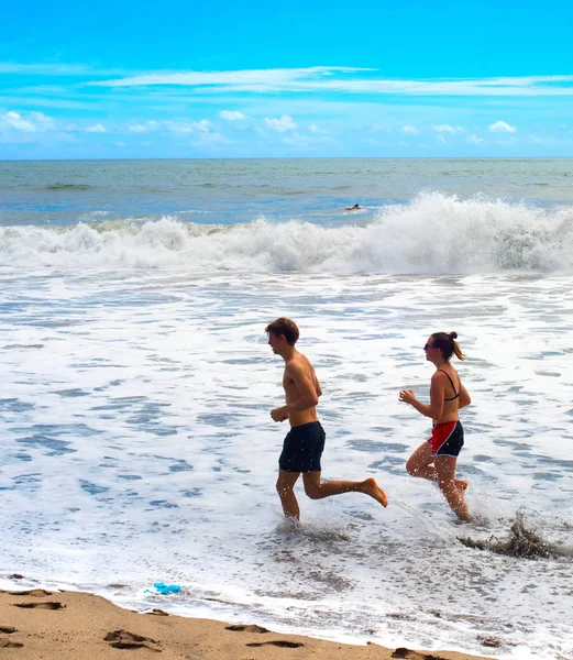 Casal correndo praia oceano Bali — Fotografia de Stock