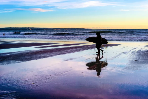 Couple with surfboards at sunset — Stock Photo, Image