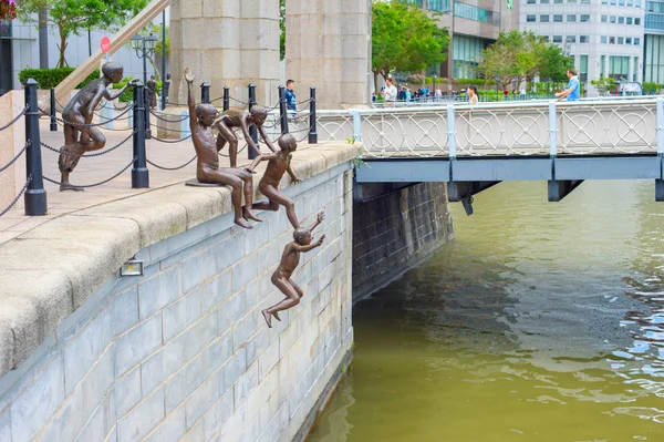 Jungen springen in Wasser satue — Stockfoto