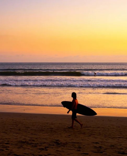 Surfista na praia ao pôr do sol — Fotografia de Stock