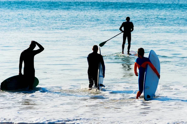 グループサーファーは、サーフィンシルエットを行く. — ストック写真