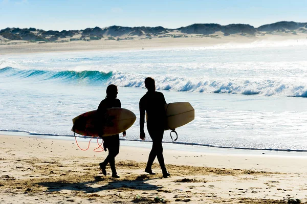 Pareja surfistas caminando playa del océano —  Fotos de Stock