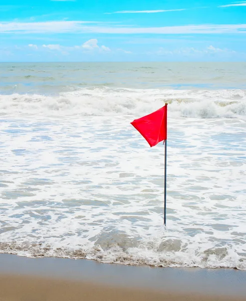 Piros zászló integet a tengerparton — Stock Fotó
