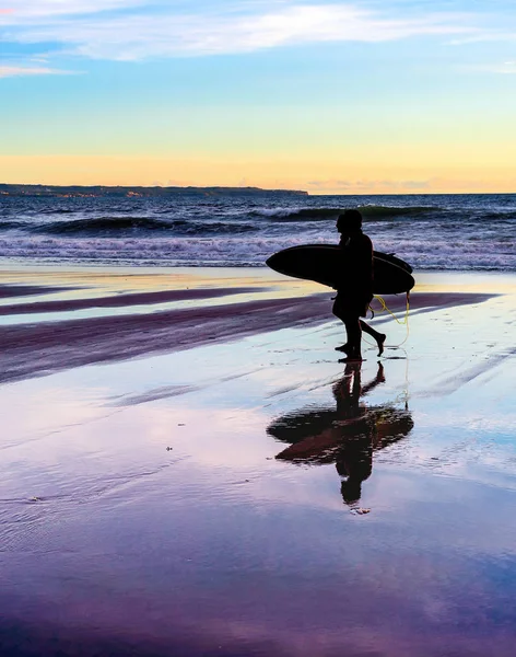 Casal com pranchas de surf ao pôr do sol — Fotografia de Stock