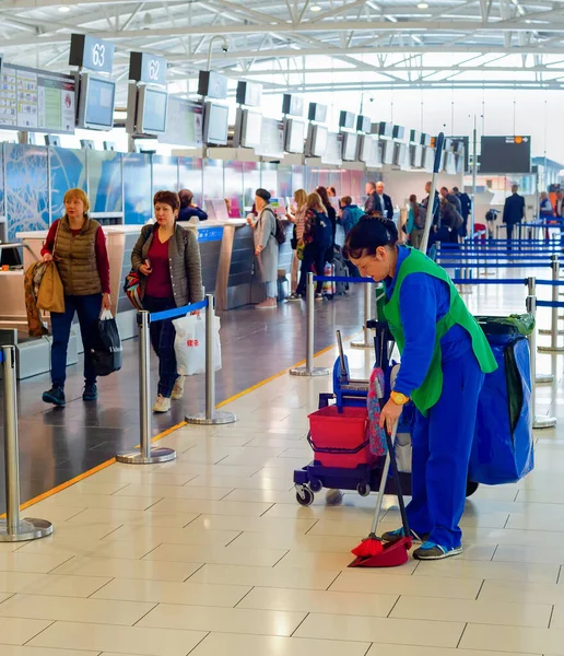 Larnaca Cyprus 2019年2月21日 在国际机场候机楼用扫帚 铲子和水桶清洗女装制服 在背景下排队检查护照 — 图库照片
