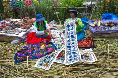 PERU - MAY 11, 2015: women in traditional dresses welcome tourists in Uros Island clipart