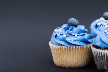 Siyah arka plan üzerine lezzetli mavi cupcake