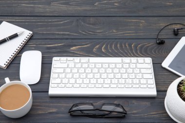 Modern çalışma alanı smartphone ve klavye kopya alanı üzerinde tahta arka plan ile. Üstten görünüm. Kahve Kupası.