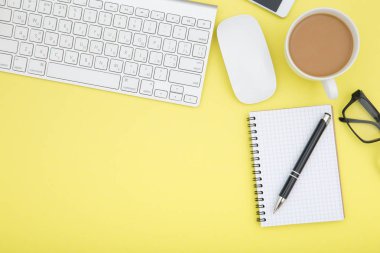 tablet, klavye, kahve fincanı ve gözlük ile çalışma alanı alanı Sarı zemin üzerine kopyalayın. Üstten Görünüm.