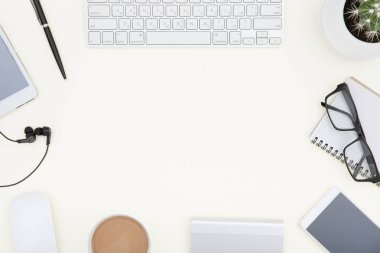 klavye ile çalışma alanı. Beyaz ofis resepsiyon masası laptop, fincan kahve ve malzemeleri ile. Kopya alanı ile üstten görünüm.