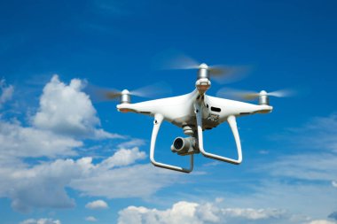 Beyaz quadrocopter yüksek gökyüzünde uçuyor