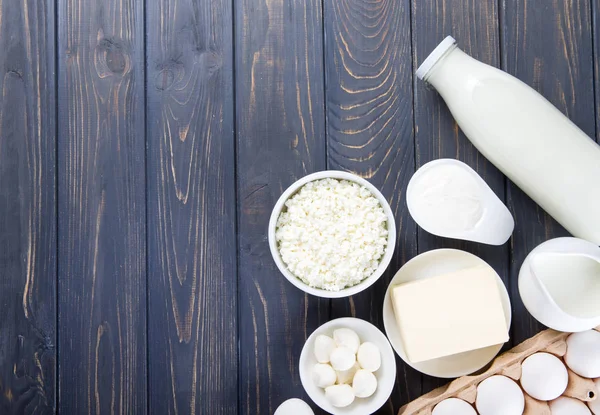 Dairy products on wooden table. Milk, cheese, egg, curd cheese a — Stock Photo, Image